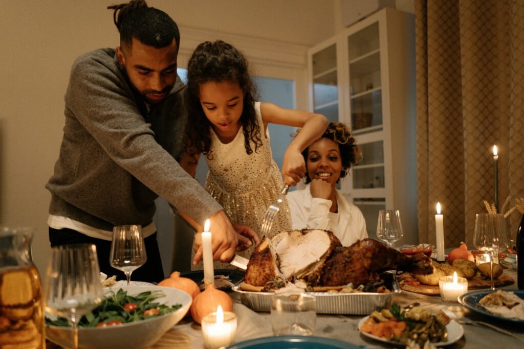A joyful family gathering around a table to celebrate Thanksgiving with a delicious turkey meal.